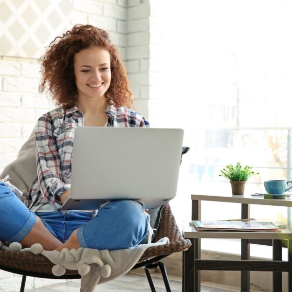 Beautiful young woman using laptop at home